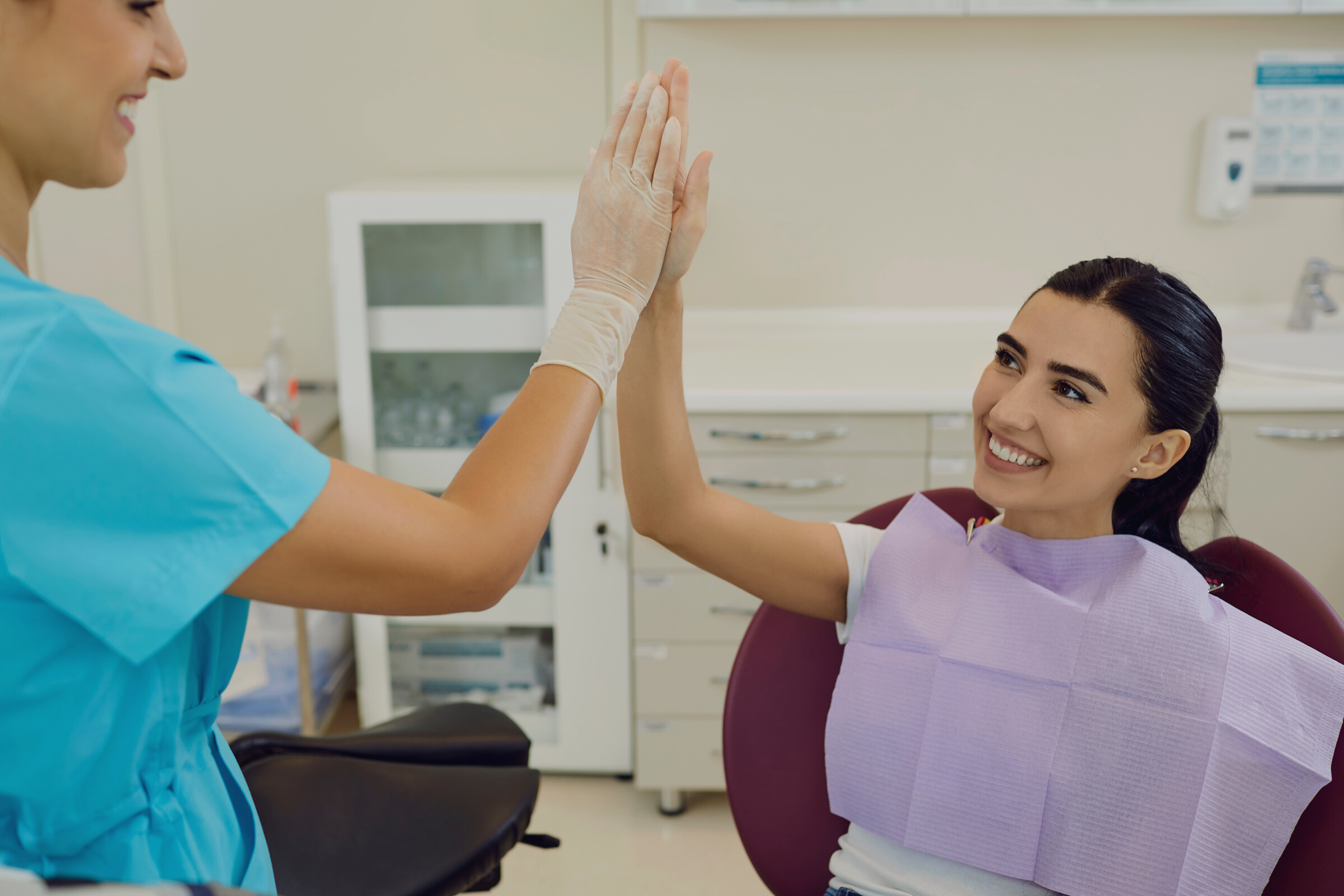 Happy Woman Is Happy with the Result of Dental Treatment and Gives Five to Her Dentist.